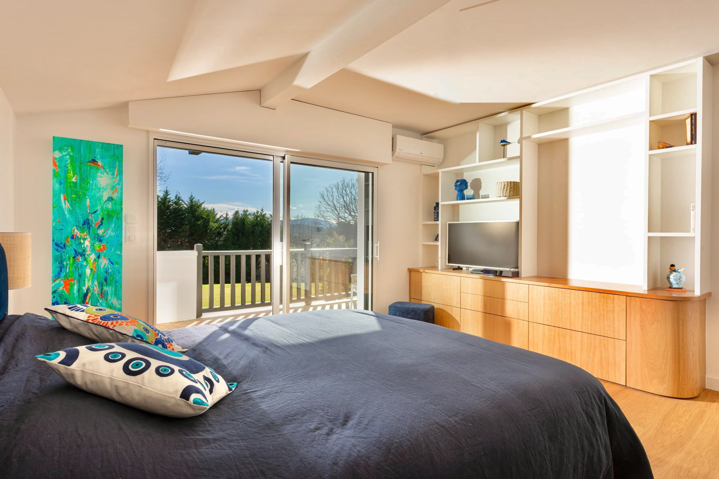 Chambre avec rangements et meuble TV sur mesure en chêne, ouverture sur terrasse